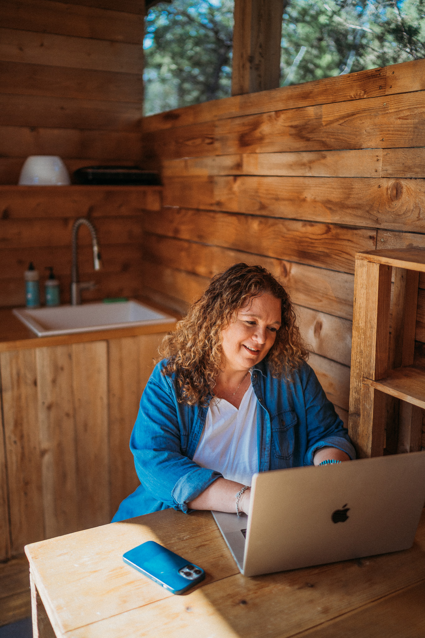 Jodi Bourne working on her laptop in a vacation rental cabin